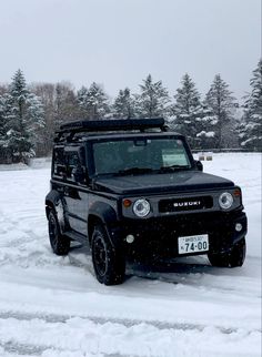 a black jeep driving down a snow covered road