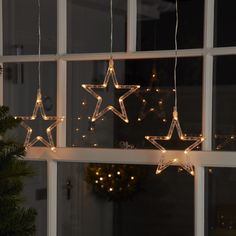 three star lights hanging from the side of a window