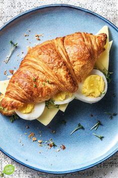 an egg and cheese croissant on a blue plate