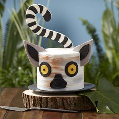 a cake decorated to look like a racoon with yellow eyes and black stripes