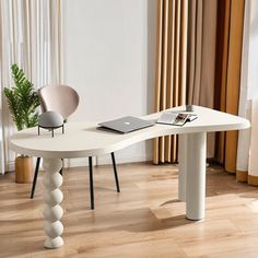 a white table sitting on top of a hard wood floor next to a window with curtains