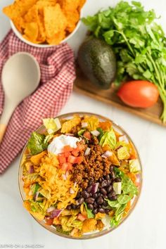 mexican salad with tortilla chips and avocado on the side next to it