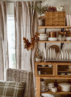 a living room filled with furniture and lots of dishes on top of a wooden shelf