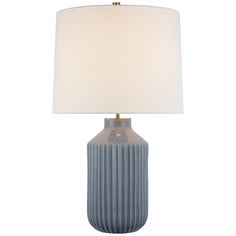 a blue and white lamp with a beige shade on it's base, against a white background