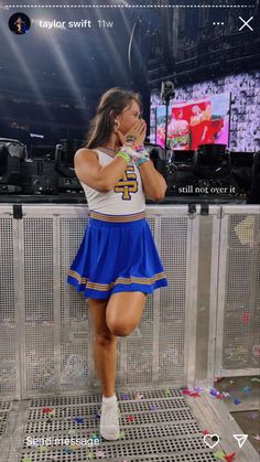 a girl in a cheerleader outfit standing on a stage