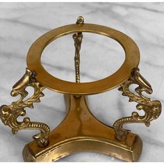 an antique brass clock with dragon handles on a marble surface