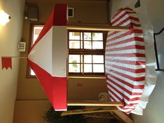 a red and white tent sitting on top of a table in front of a doorway