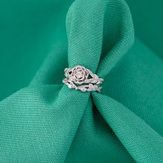 a diamond ring sitting on top of a green cloth