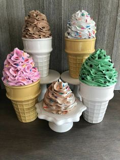 four ice cream cones with sprinkles in them sitting on top of each other