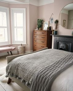 a bedroom with a bed, dresser and mirror in it's centerpieces