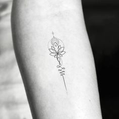 a black and white photo of a flower tattoo on the left inner arm, with an arrow in the middle