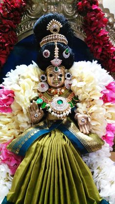 an idol is displayed in front of flowers