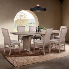 a dining room table and chairs in front of an arched window with a vase on it