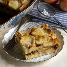 a piece of pie sitting on top of a plate next to a pan filled with apples