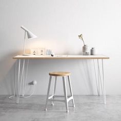 a table with two stools next to it and a clock on the wall behind it