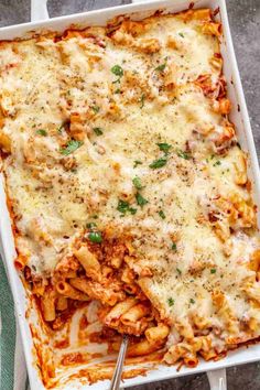 a casserole dish filled with pasta and meat, topped with parmesan cheese