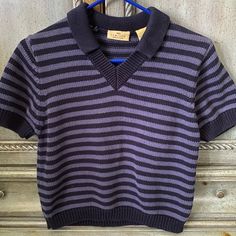 Short Sleeve, 100% Cotton Top With Navy Blue And Lighter Blue Alternating Stripes. This Shirt Is Heavier Than A Standard T-Shirt Probably Closer To A Lightweight Sweater. It Has A Slight V Neck With A Collar Attaching At The Neckline. The Neck And Collar Are Both Solid Navy Blue, As Are 1” Bands At The Bottom Of The Sleeves And Around The Entire Bottom. This Shirt Has Never Been Worn (Nwot). Armpit To Armpit Measures 18”; Shoulders Seem To Bottom Measures 18.5”. Retro Blue Tops For School, Cotton V-neck Top For School, Casual V-neck School Tops, Casual V-neck Tops For School, Navy Long Sleeve Top With Striped Collar, Vintage Blue V-neck Top, Blue Collared T-shirt With Ribbed Collar, Vintage Blue Short Sleeve Camp Shirt, 90s Blue Long Sleeve T-shirt