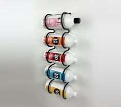 a wall mounted spice rack with six different colored spices on it and numbers painted on the sides