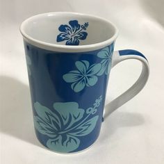 a blue and white coffee cup with flowers on it