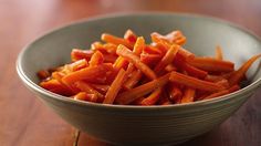 a bowl filled with sliced carrots on top of a wooden table