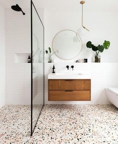 a bathroom with a sink, mirror and toilet in the corner next to a bathtub