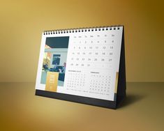 a desk calendar with the image of a house on it is shown in front of a gold background