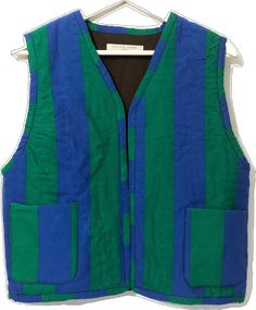 a blue and green striped vest hanging on a white hanger with a black shirt underneath it