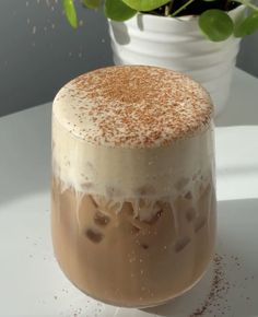 a cake sitting on top of a white table next to a potted green plant