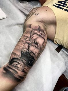 a man with a ship tattoo on his arm