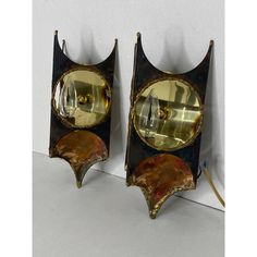 pair of art deco style mirrors with gold and black accents, on white wall background