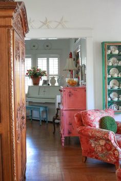 a living room filled with furniture next to a wooden floor covered in lots of clutter