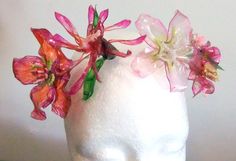 a white mannequin head with pink flowers on it