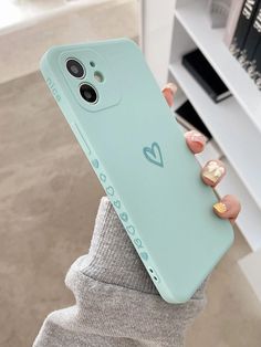 a person holding up a phone case with a heart on it