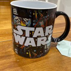 a star wars coffee mug sitting on top of a wooden table next to a tag