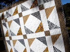 a quilted wall hanging with zebra and cheetah patterns on it's sides