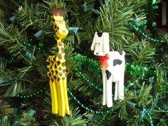 two giraffes are hanging from a christmas tree