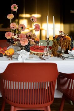 the table is set with watermelon slices, fruit, and candlesticks