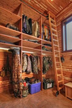 a room with wooden walls and shelves filled with clothes