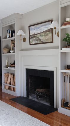 a living room with a fire place and bookshelves on the wall above it