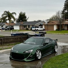 a green sports car parked in the rain