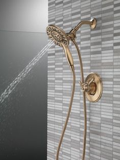 the shower head and handset are shown in this bathroom setting with mosaic tiles on the wall