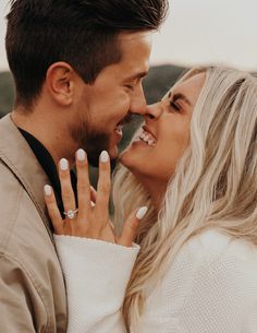 a man and woman smiling at each other with their wedding rings on their fingers,