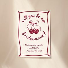 a greeting card with an image of two cherries and the words will you be my bridesmaid?