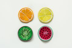 four pieces of fruit are arranged in the shape of an orange, watermelon and lemon slice