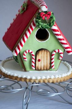 a green gingerbread house with candy canes on top