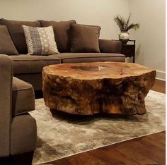 a living room filled with furniture and a large tree stump table on top of a rug