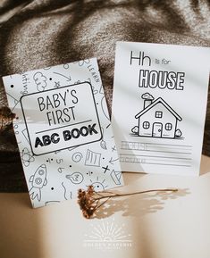 two baby's first abc book cards sitting on top of a bed