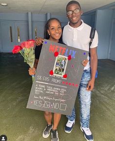 a man and woman holding a sign with flowers