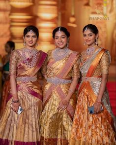 three women standing next to each other on a runway