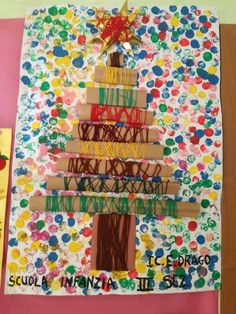 a christmas tree made out of cardboard and colored paper on top of a bulletin board